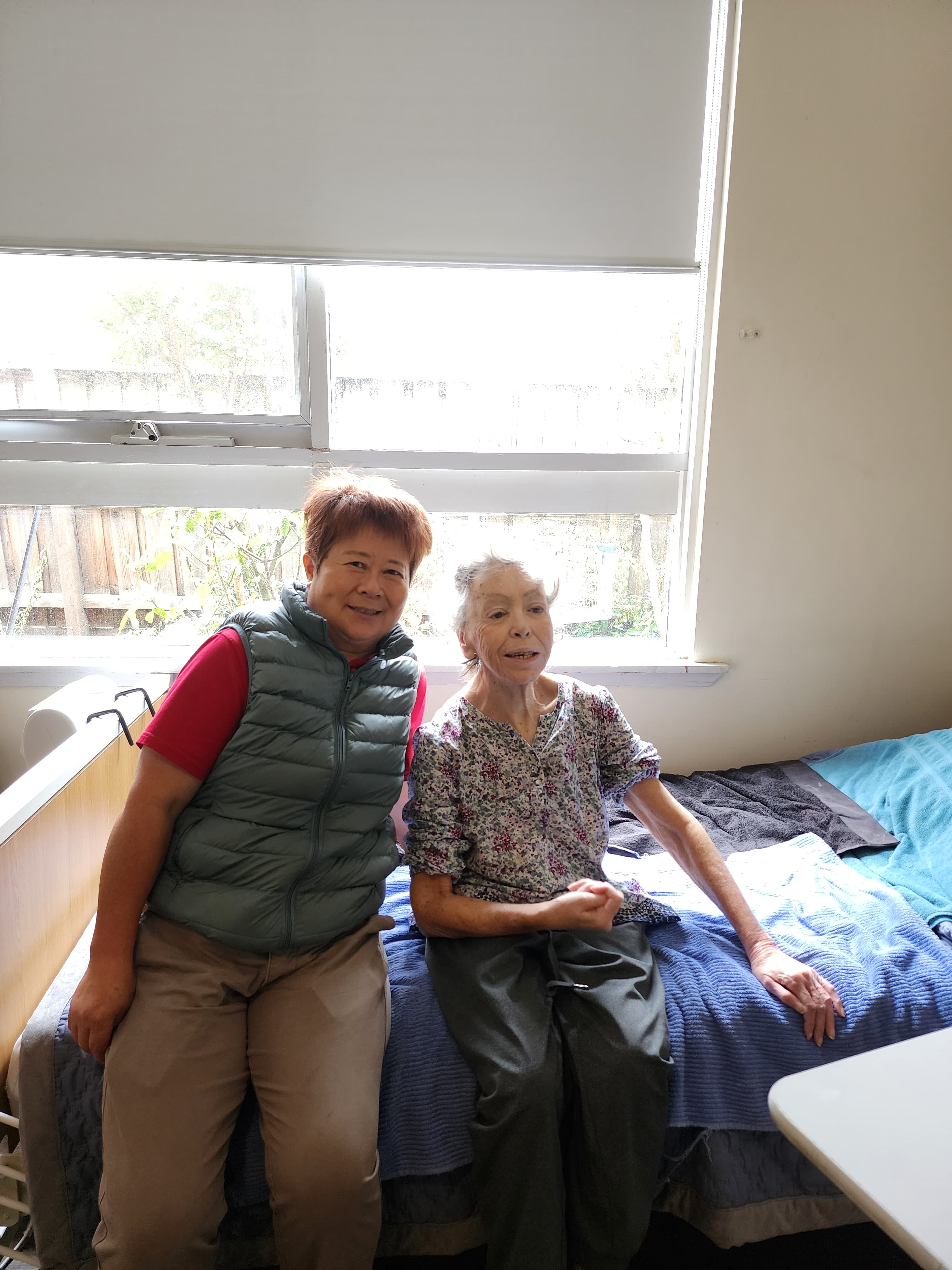 Resident and carer together in a bright room